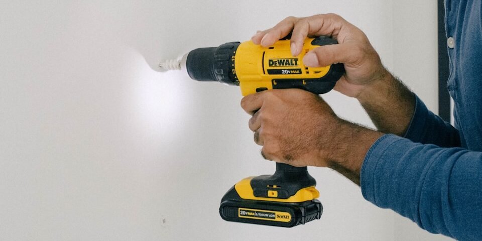 person holding yellow and black cordless hand drill